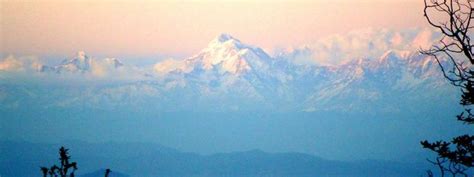 the mountains are covered with snow and clouds in the distance, as seen ...