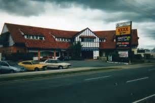 Two Cars Are Parked In Front Of A Store On The Side Of The Road With