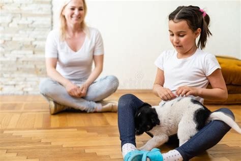 Madre Joven Y Su Hija Jugando Y Pasando El Rato Con Su Nuevo Perrito En