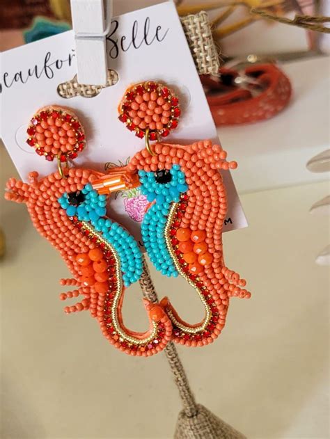 An Orange And Blue Beaded Earring Hanging From A Hook