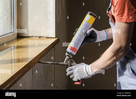 Worker Is Using A Polyurethane Foam For Installation Of Window Sill