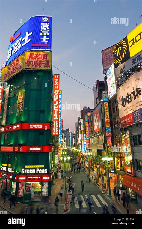 Japan, Tokyo, The busy neon lit streets outside the Shinjuku Station ...