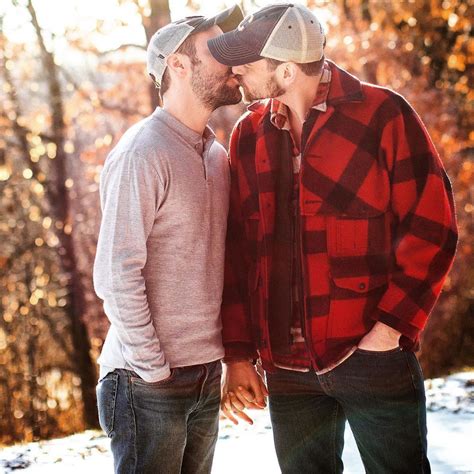 Two Men Standing Next To Each Other In The Woods