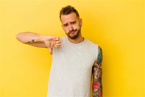 Premium Photo Young Tattooed Caucasian Man Isolated On Yellow