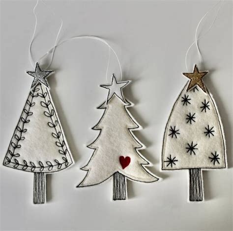 Three Christmas Tree Ornaments Hanging From Strings