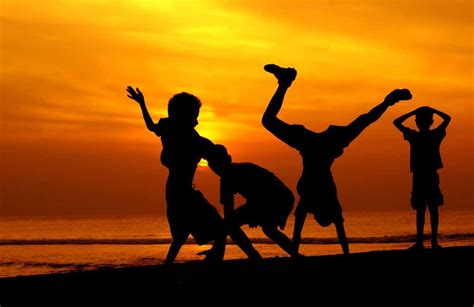 Children Playing At Sunset On Beach Famlii