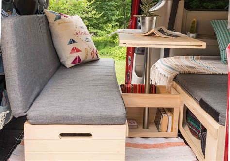 The Inside Of A Camper With A Couch Table And Storage Area In It