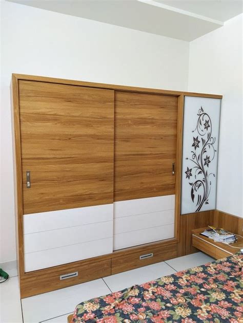 A Bed Room With A Neatly Made Bed And Wooden Closets