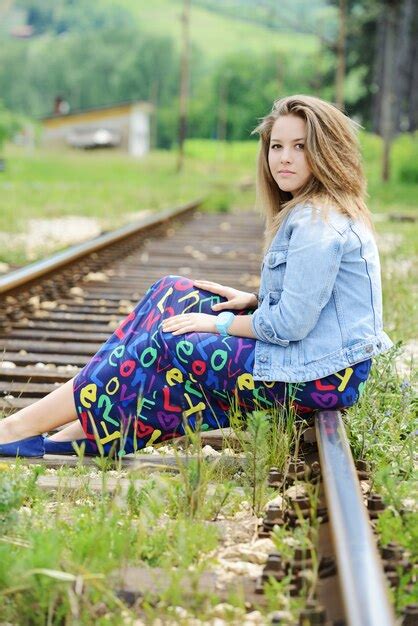 Mujer sentada en las vías del tren Foto Premium