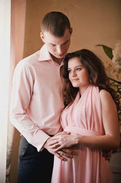 Premium Photo Pregnant Woman And Man In Arms Posing In A Classic Interior