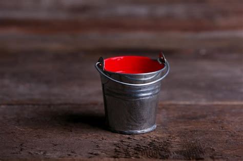 Premium Photo | Metal bucket with colorful paint on wooden background