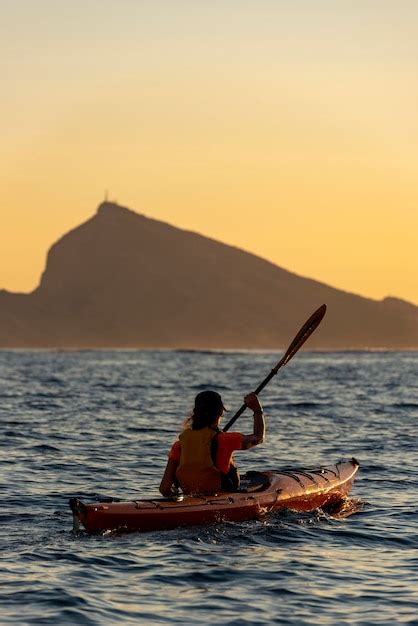 Hembra adulta remando un kayak de mar en el mar mediterráneo al