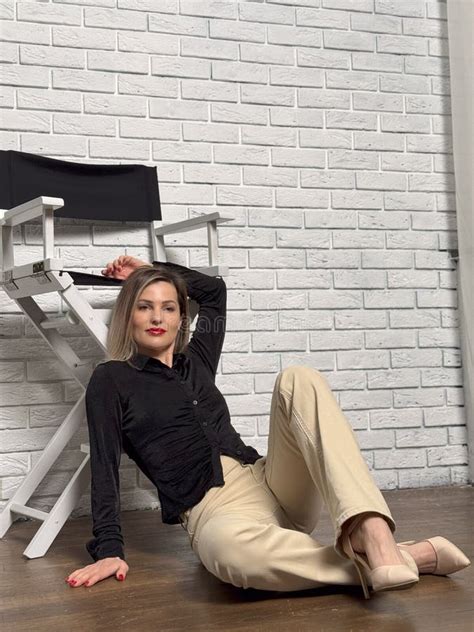 Blonde Fashion Model In Pastel Beige Suit Sitting On Chair Stock Photo Image Of Studio