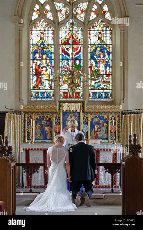 A Newly Married Couple Receiving A Blessing At The Altar In A Stock