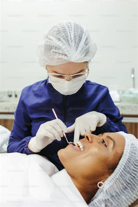 A Woman Getting Her Teeth Checked By A Dentist Photo Dental Care Image On Unsplash