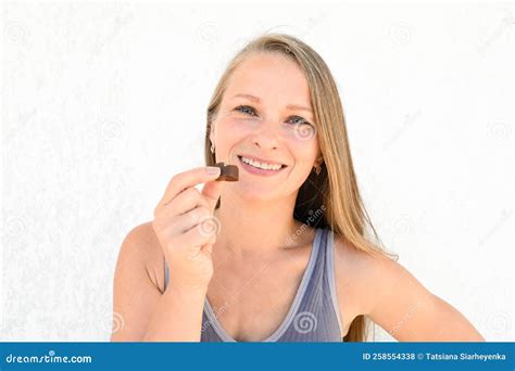 Une Belle Femme Blonde Heureuse De 35 Ans Avec Un Bonbon Au Chocolat Entre Ses Mains Fermer Le