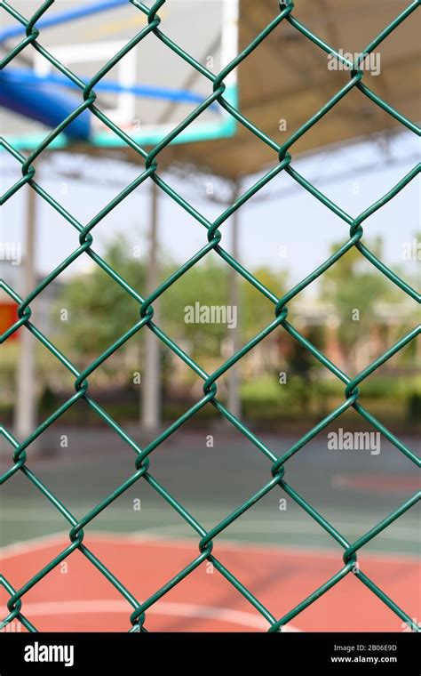 outdoor basketball court behind a metal fence vertical composition ...