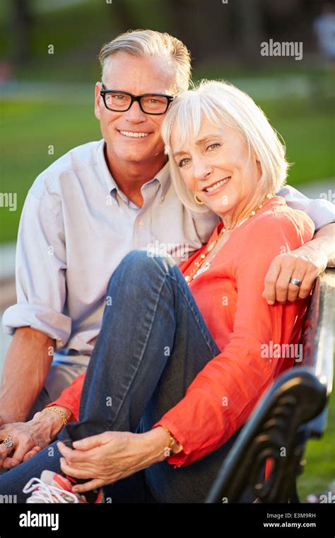 Mature Romantic Couple Sitting On Park Bench Together Stock Photo Alamy