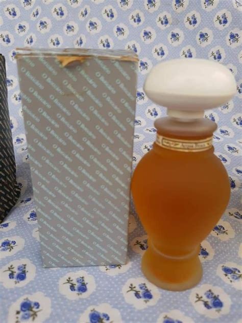 A Bottle Of Honey Sitting Next To A Box On A Tablecloth With Blue And