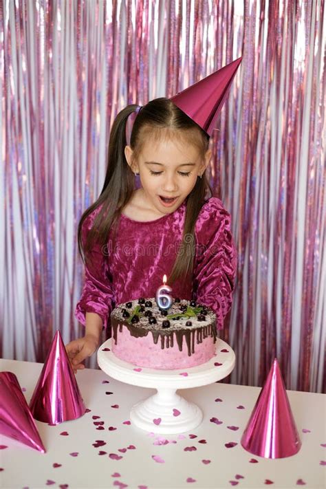 Girl Blows Out Burning Candle On Cake Making Cherished Wish On Sixth Birthday Stock Image