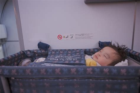 Premium Photo Baby Sleeping In Bassinet On Airplane