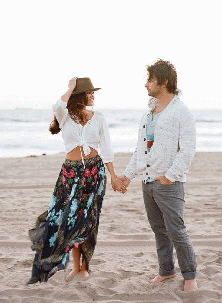 A Man And Woman Holding Hands On The Beach