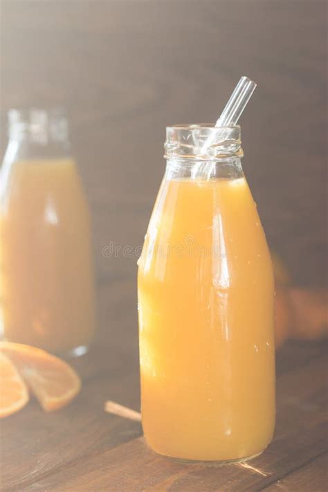 Freshly Squeezed Orange Juice In A Glass Bottle On A Wooden Background Drink With A Bottle With