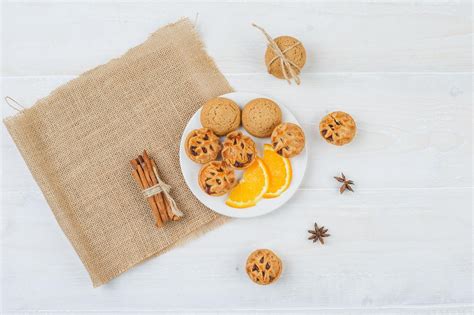 Free Photo | Jelly filling cakes,cookies and orange in a plate with cinnamon and a placemat