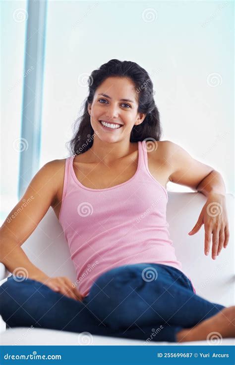 Happy Woman Sitting On Sofa Portrait Of Happy Woman Sitting On Sofa