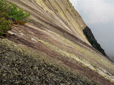 Steep textured granite mountain slope. Stone texture. Cross section of