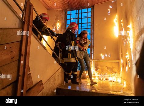 Brave Fireman Descends Stairs Of A Burning Building And Holds Saved