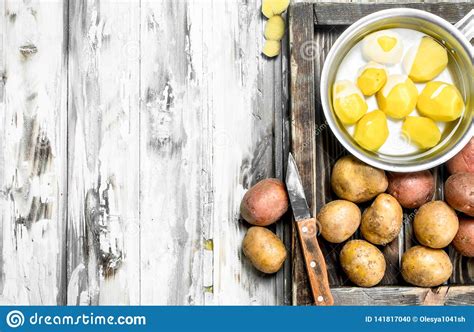 Patatas Peladas En Un Cazo Con Las Patatas Sin Pelar En La Bandeja Con