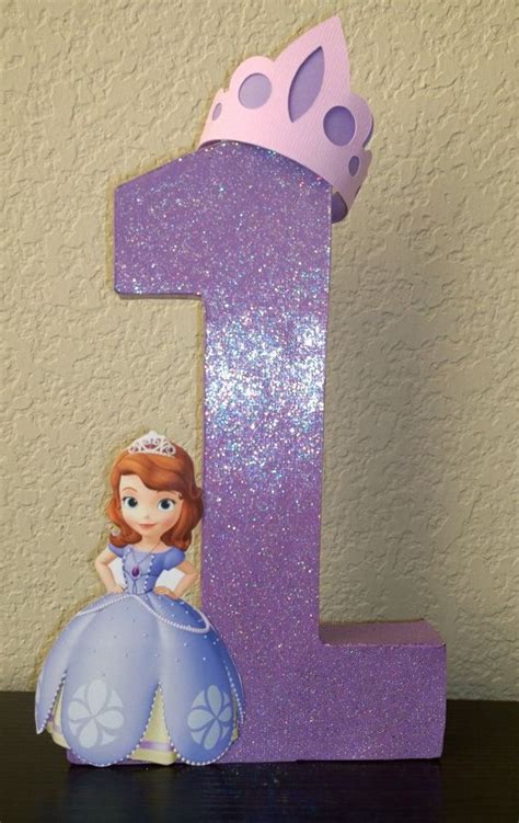 a purple number one with a princess sitting on it's side and a pink crown