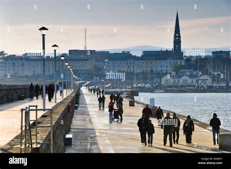 People Walking Dun Laoghaire East Pier In Winter In Dublin In Ireland