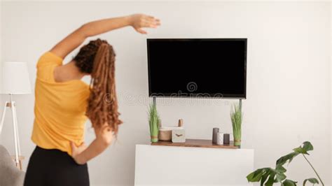 Fitness Woman Exercising Stretching Arms Watching Tv At Home Stock