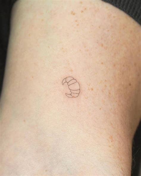 Tiny Minimalistic Croissant Tattoo Located On The