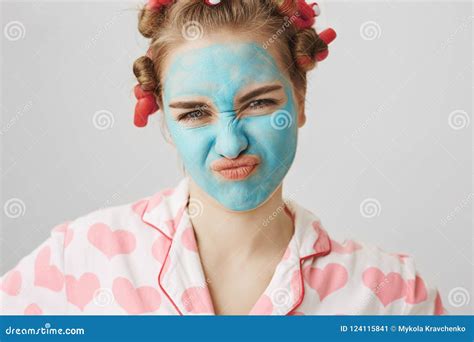 Close Up Portrait Of Nasty Meany Girl In Facial Mask And Hair Curlers Wearing Pyjamas And