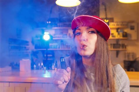 Joven Mujer Bonita Con Gorra Roja Fumar Un Cigarrillo Electrónico En La