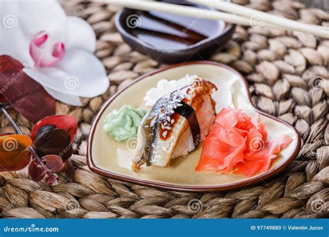 Sushi Set Nigiri And Sushi Rolls Decorated With Flowers On Bamboo