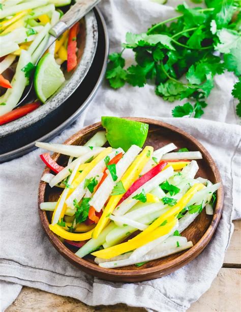 Jicama Salad With Honey Lime Dressing On A Small Wooden Plate With A