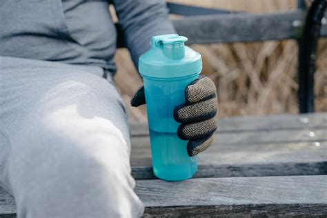 Thirsty man drinking water on barrier · Free Stock Photo