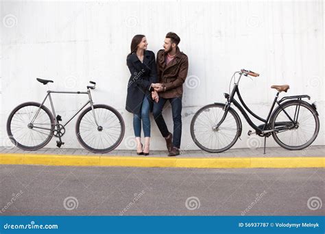 Pares Jovenes Que Se Oponen A La Pared Y Al Abrazo Imagen De Archivo