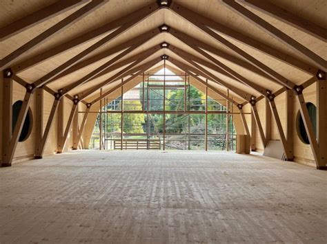 The Inside Of A Large Wooden Building With Multiple Windows And Wood