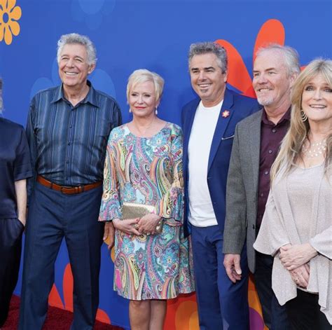 a group of people standing next to each other on a red carpet