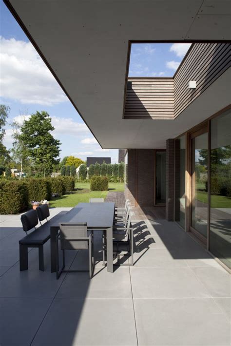 An Outdoor Dining Area With Table And Chairs On Concrete Flooring Next