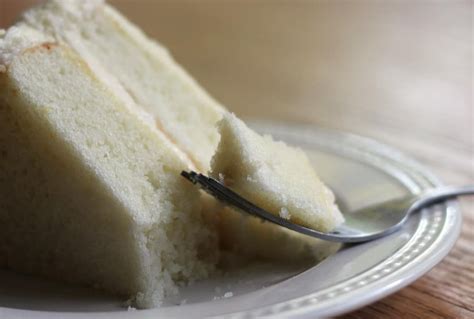 A Piece Of Cake On A White Plate With A Fork Sticking Out Of The Slice