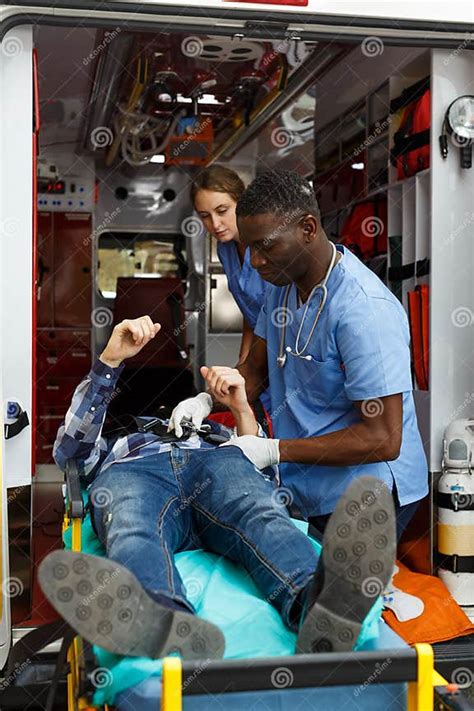 Ambulance Team Laying Patient On Stretcher Stock Image Image Of