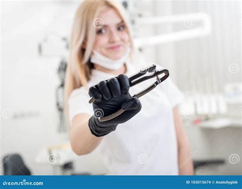 Portrait Of Young Attractive Female Dentist Holding Dental Tool At The