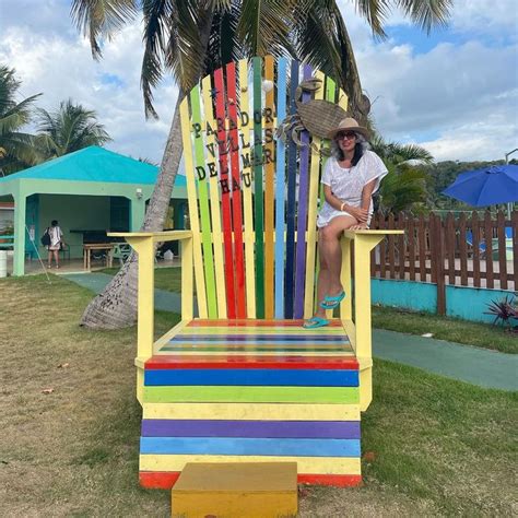 A Person Sitting On A Colorful Chair In The Grass