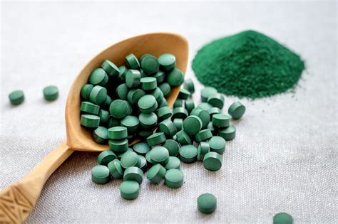 Espirulina De Algas Verdes En Tabletas Y Polvo Sobre Un Fondo De